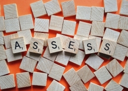 Wooden tiles spelling out 'Assessment'