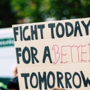 Photo of a crowd with someone holding a banner saying 'Fight today for a better tomorrow'