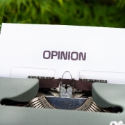 Image of a typewriter with a piece of paper with the word 'opinion' typed on it